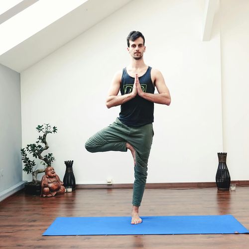 Man in a meditative pose after a workout, looking focused.