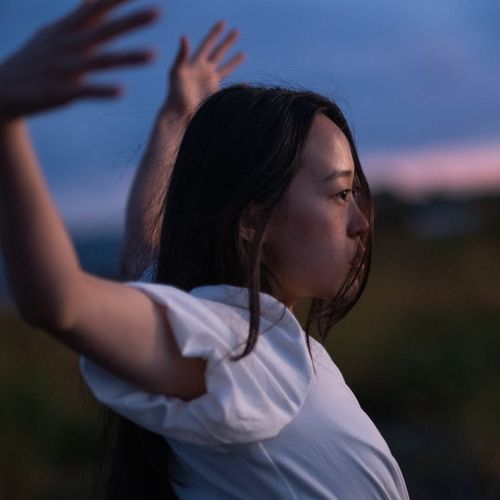 Silhouette of a person stretching against a serene background.